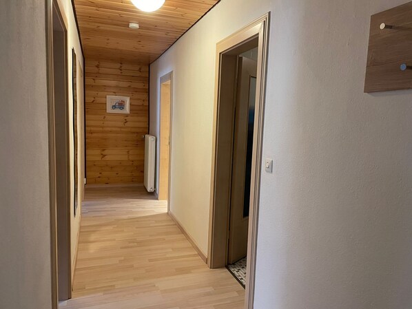 Ein Flur mit Holzwänden, einem Heizkörper und einer Tür.
