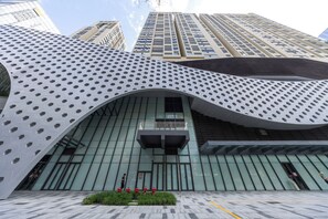A modern building with a distinctive geometric facade, a central entrance, and a small balcony. - Bailai audio & video yaju (Shenzhen)