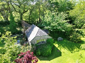 A stone house surrounded by lush greenery and a well-maintained lawn. - Beautiful Countryside Barn Retreat in the Tamar Valley (Cornwall)