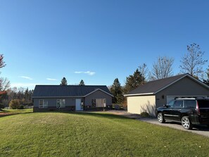 A residential area with two houses, a driveway, and a black SUV parked in front of one house. - Northern Oasis in the Warroad Estates (Warroad)
