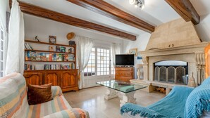 A living room with a fireplace, bookshelves, a television, and a sofa. - Large House with Private Pool in a Peaceful Setting – Pets Welcome (Valréas)