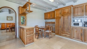 A kitchen with wooden cabinets, a dining table, and chairs. - Large House with Private Pool in a Peaceful Setting – Pets Welcome (Valréas)