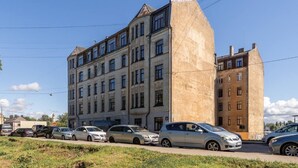 Un immeuble à plusieurs étages avec un grand parking situé à l’avant.