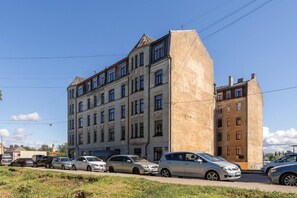 Un edificio de varios pisos con un amplio estacionamiento al frente.