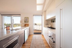 Eine moderne Küche mit großem Fenster und Blick ins Freie, inklusive eingebautem Backofen.