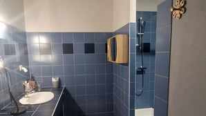 Un baño con dos lavamanos, una ducha y un inodoro.