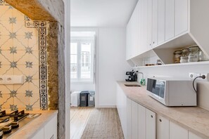 A modern kitchen with white cabinets, a microwave, and a coffee maker. - Stunning Views | Authentic Lisbon Living (Lisbon)