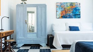 A room with a bed, a wardrobe, a desk, and a colorful abstract painting. - Floating Over the Sado | Arrábida, Beaches & Town (Setúbal)