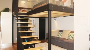 A modern interior with a staircase, a sofa, and a glass partition. - Modern Coastal Ocean Breeze Studio | Beach & Town (Setúbal)