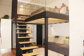 Ein modernes Interieur mit Treppe, einer Couch und einer Glaskonstruktion.