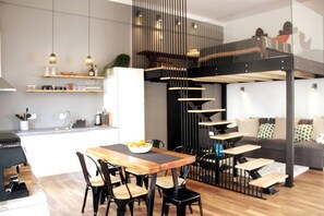 Eine moderne Küche mit Essbereich, einer Treppe und einem Wohnzimmer mit Sofa.