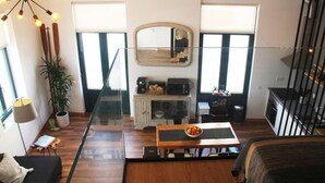 A modern interior with a dining area, kitchen, and a large window. - Modern Coastal Ocean Breeze Studio | Beach & Town (Setúbal)