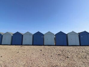 Eine Reihe von Strandhäusern vor einer sandigen Küste.
