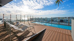 A rooftop pool with wooden deck and lounge chairs. - Oceanique Penthouse in Leighton Beach (North Fremantle)
