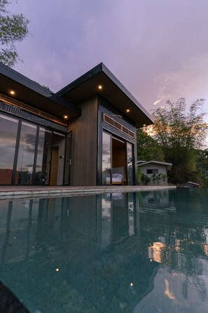 A modern house with a swimming pool, large sliding glass doors, and a covered outdoor seating area. - The Bali Escape Cabin With Pool (Cebu City)