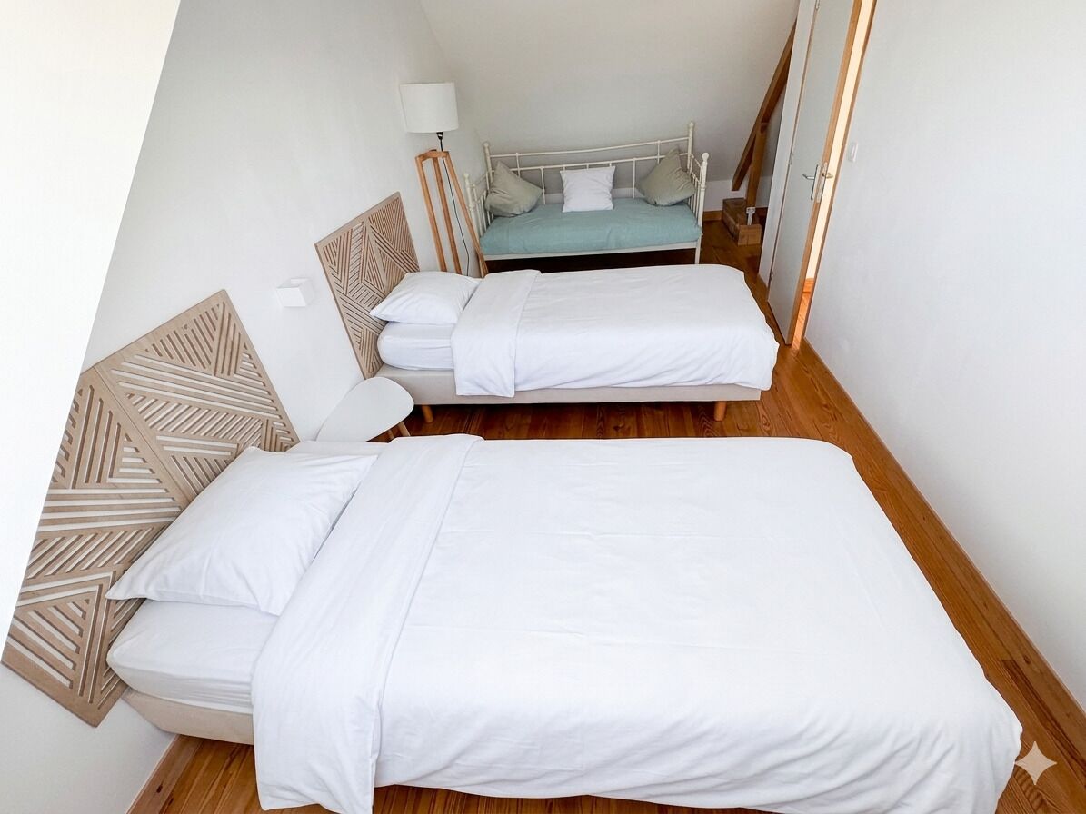 Ein Schlafzimmer mit zwei Betten, einem Holzkopfstück, einem Nachttisch und einer Lampe.