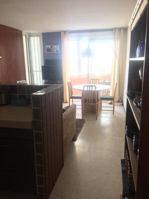 A compact kitchen with a dining area, a TV, and a view of the outdoors. - View of port and sea (Le Barcarès)