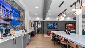 Una cocina moderna con barra, área de café y comedor con taburetes de bar.