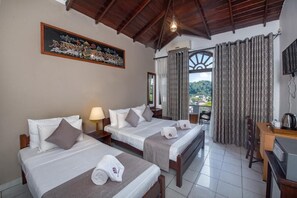 Habitación de hotel con dos camas, un escritorio, una silla, un televisor y una ventana con cortinas.