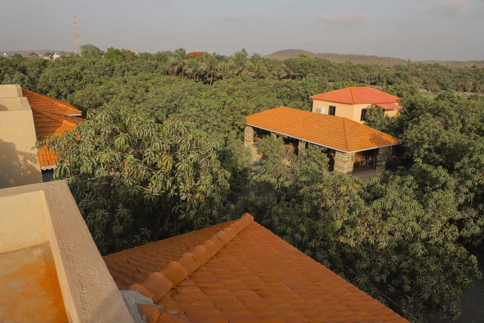 Ein Gebäude mit rotem Dach, umgeben von üppiger Vegetation.