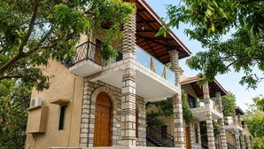 Ein mehrstöckiges Gebäude mit einer Stein-Fassade, einer Holztür und einem Balkon mit Metallgeländer.