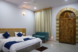Un dormitorio con cama, una silla, una puerta de madera y un ventilador de techo.