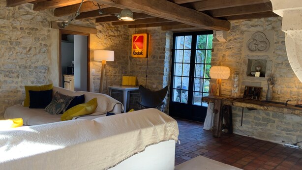 A rustic room with a bed, a table, and a window. - 4-Star Longère “L'Albizia” with Morvan Views (Billy-Chevannes)