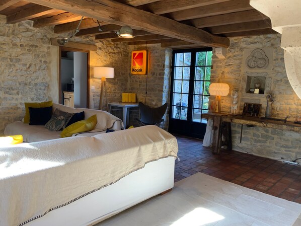A rustic room with a bed, a table, and a window.