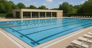 Piscina con carriles de natación, vestuarios y sillas de descanso.