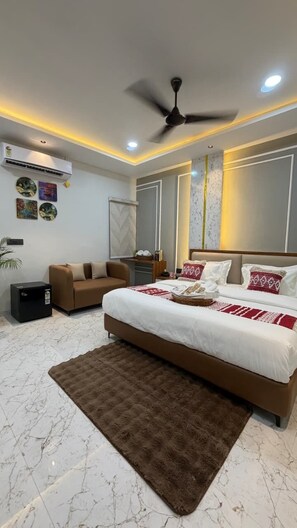 A modern bedroom with a bed, ceiling fan, air conditioning unit, and a brown rug. - Supreme Stays (Indore)