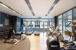 Un gimnasio con cintas de correr, elípticas y pesas sueltas.