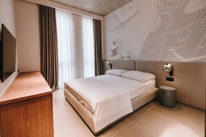 A modern hotel room with a bed, a desk, and a TV. - The Saad by MHG (Tbilisi)