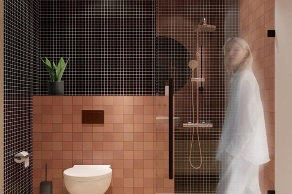 A bathroom with a shower, toilet, and a potted plant.