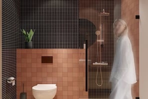 Baño con ducha, inodoro y una planta en maceta.