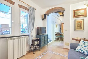 A living room with a TV, a cabinet, a sofa, and a chessboard. - La Dimora Blu (Albenga)