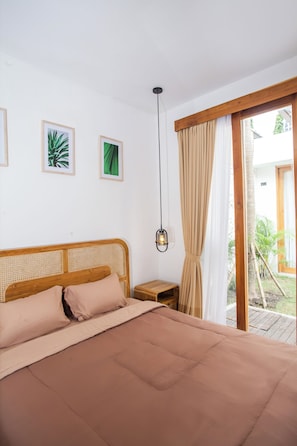 Un dormitorio con cama, mesita de noche, lámpara colgante y vistas al exterior.