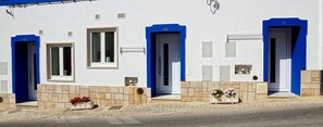 Un edificio con porte numerate, facciata in pietra e fioriere.