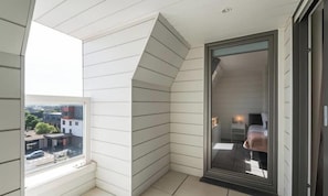 Ein Eckzimmer mit großem Fenster, einer Schiebetür und Blick auf die Straße.