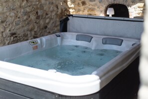 Ein Whirlpool mit Steinwand im Hintergrund.