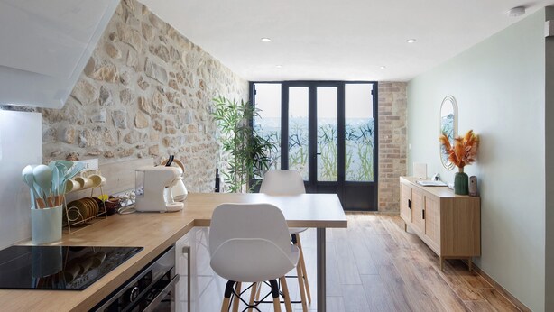 Una cocina moderna con pared de piedra, un ventanal y vistas de la ciudad.