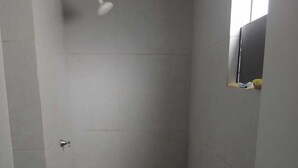 A small, enclosed shower area with a toilet and a wooden floor. - 2-bedroom apartment with air conditioning (João Pessoa)