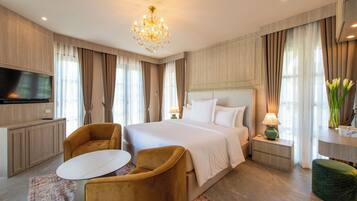 Une chambre d’hôtel avec un grand lit, une télévision, un bureau et une chaise.