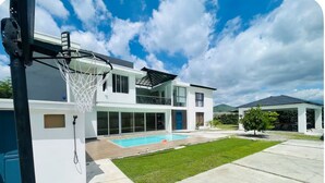 A modern two-story house with a swimming pool, a basketball hoop, and a covered patio. - Marvelous 3-bedroom house with AC in charming in Bani, Pizarrete (Pizarrete)