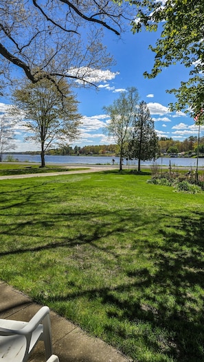 A park with a grassy area, trees, a lake, and a path. - Bell Inn Cottage - Sanford Lake (Sanford)