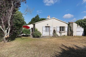 A single-story house with a front door, a small porch, and a window.