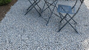 A stone wall, a round table with a vase, and four chairs. - Mimi's House (Maubert-Fontaine)