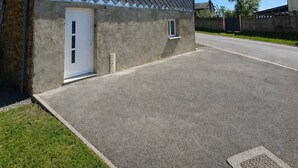 A single-story building with a sloped roof, a small porch, and a driveway. - Mimi's House (Maubert-Fontaine)