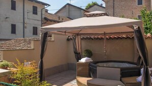 A patio area with a hot tub, wicker furniture, and a canopy. - ByVigin Azalea – Elegance, Relaxation, and a Private Outdoor Jacuzzi (Magliano Alfieri)