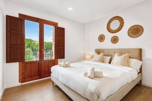 A bedroom with a large bed, wooden shutters, and a view of greenery outside. - Sea View Apartment with Terrace - Sunset (La Vila Joiosa)