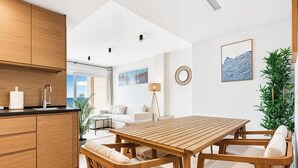 Uma cozinha moderna com armários de madeira, uma mesa de jantar com cadeiras, um sofá e um abajur.